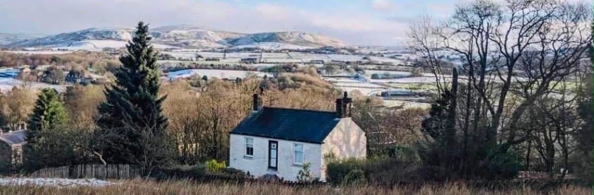 The white cottage above Ramsbottom with frost on the surrounding fields and hills
